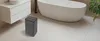 A dehumidifier is placed on the floor next to a modern bathtub and vanity in a bathroom. Produktbild-Vorschau