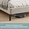 A robot vacuum cleaner is shown cleaning under a bed, illustrating the bed's clearance height. Produktbild-Vorschau