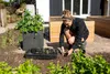 A woman is planting seedlings in a garden. Produktbild-Vorschau