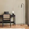 A minimalist home office setup with a desk, chair, and floor lamp. Produktbild-Vorschau