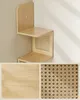 A wooden corner shelf with woven cane accents is displayed on a light gray wall. Below the shelf, there are two close-up shots: one showing the wood grain and the other showing the woven cane pattern. Produktbild-Vorschau