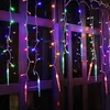 Icicle-shaped LED lights hanging in front of a window at night. Náhled obrázku produktu