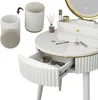 A white vanity table with a drawer open, showing makeup and glasses inside. A stool and a container are shown to the left. Podgląd zdjęcia produktu