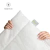 Hands holding a white quilted blanket or duvet. Produktbild-Vorschau