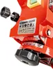 A close-up view of a red electric chain sharpener, focusing on the label and adjustment mechanism. Podgląd zdjęcia produktu