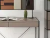 A close-up view of a modern desk with a book and a decorative cactus. Voir les images du produit