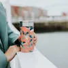 A person holding a patterned thermal mug on a railing with a blurred background of buildings and water. Anteprima dell’immagine prodotto