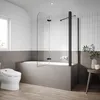 A modern bathroom with a bathtub, shower screen, and toilet. Anteprima dell’immagine prodotto