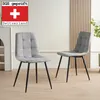 Two gray upholstered dining chairs with black metal legs are shown in a room with a light-colored wall and wooden paneling. Produktbild-Vorschau