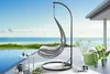 A hanging chair on a patio overlooking the ocean. Produktbild-Vorschau
