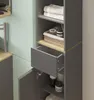 A close-up view of a bathroom cabinet with an open drawer and door, showing towels and toiletries. Voir les images du produit