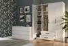 A bedroom scene with a white wardrobe and dresser against a patterned wall. Anteprima dell’immagine prodotto
