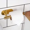 A close-up shot of a gold toilet paper holder mounted on a white tiled wall, with a roll of toilet paper on it. Produktbild-Vorschau
