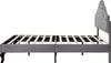 A side view of a gray upholstered bed frame with a tufted headboard and a wooden slat support system. Produktbild-Vorschau