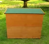 A wooden rabbit hutch with a green roof sits on a grassy lawn. Produktbild-Vorschau
