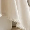 A close-up of a cream-colored fabric with frayed edges, draped over a white object. Produktbild-Vorschau