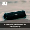 A black Sony Bluetooth speaker is partially submerged in water on a sandy beach. Voir les images du produit
