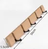A wooden coat rack with five black hooks is shown against a white background. Dimensions are indicated by annotations. Produktbild-Vorschau