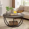 A round coffee table with a teapot and cups on it, placed in a living room setting with a sofa and fireplace in the background. Produktbild-Vorschau