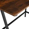 Close-up of a brown wooden desk with black metal legs. Náhled obrázku produktu