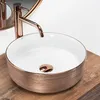 A close-up shot of a rose gold and white vessel sink with a rose gold faucet. Produktbild-Vorschau