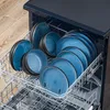 A dishwasher rack filled with blue ceramic plates and bowls. Náhled obrázku produktu