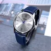 A close-up shot of a Casio watch with a silver dial and a blue leather strap, set against a blurred background of buildings. Voir les images du produit