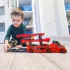 A young boy is playing with a toy car carrier truck and cars on a wooden floor. Náhled obrázku produktu