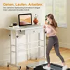 A woman is jogging on a treadmill next to a height-adjustable desk with a laptop. Podgląd zdjęcia produktu