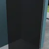 A corner view of a modern shower enclosure with dark tinted glass walls and a light blue frame, set against a teal wall and a concrete floor. A hint of greenery is visible outside. Produktbild-Vorschau