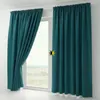 Two teal blackout curtains are shown hanging on a window rod, with one curtain partially drawn to the left. The window looks out onto a landscape. Produktbild-Vorschau