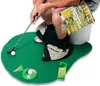 A person is sitting on a toilet with a golf putting mat and accessories in front of them. Anteprima dell’immagine prodotto