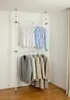 A two-tiered telescoping wardrobe system with clothes hanging on it, set up in a corner of a room. Produktbild-Vorschau