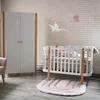 A nursery room with a crib, wardrobe, and decorative elements. Produktbild-Vorschau