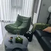 A modern living room with a green sofa and a black coffee table. Voir les images du produit