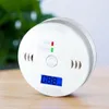 A white carbon monoxide detector with a digital display sits on a wooden surface. Produktbild-Vorschau