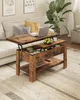 A lift-top coffee table with hidden storage is shown in a living room setting, next to a sofa and a large plant. Voir les images du produit