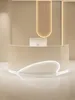 A modern reception desk with curved lines and integrated lighting. Voir les images du produit
