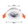 A white recessed LED spotlight with orange clips is shown against a white background. Dimensions are indicated by lines and text. Produktbild-Vorschau