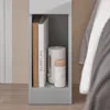 A close-up view of a narrow bedside table with items on its shelf. Produktbild-Vorschau