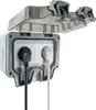 An outdoor electrical socket with two outlets, one with a black plug and the other with a white plug, is shown with its protective cover open. Anteprima dell’immagine prodotto
