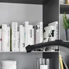 A close-up view of books on a shelf, with a vacuum cleaner nozzle in the foreground. Produktbild-Vorschau