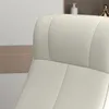 A close-up view of a cream-colored recliner chair, showing the textured upholstery and stitching. The background includes a wall and a shelf with decorative items. Produktbild-Vorschau