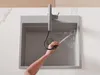 A person is using a kitchen faucet with a pull-out spray in a sink. Produktbild-Vorschau