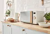 A modern kitchen counter with a microwave, kettle, bread, and soup. Anteprima dell’immagine prodotto