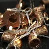 A close-up shot of copper pipe fittings intertwined with a string of LED lights. Produktbild-Vorschau