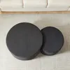 Two round ottomans/coffee tables are placed on a rug in front of a sofa. Produktbild-Vorschau