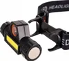 A close-up shot of a black LED headlamp with a yellow COB light strip and a small orange-rimmed light. Anteprima dell’immagine prodotto