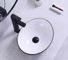 A white ceramic vessel sink with a black rim and a black faucet on a light gray tiled surface. Náhled obrázku produktu