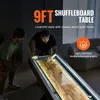 Two men playing shuffleboard in a dimly lit room with LED lighting. Produktbild-Vorschau
